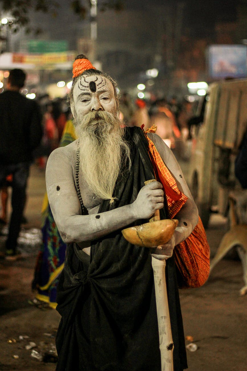 Aghori,a man dressed in white with a long beard and a stick