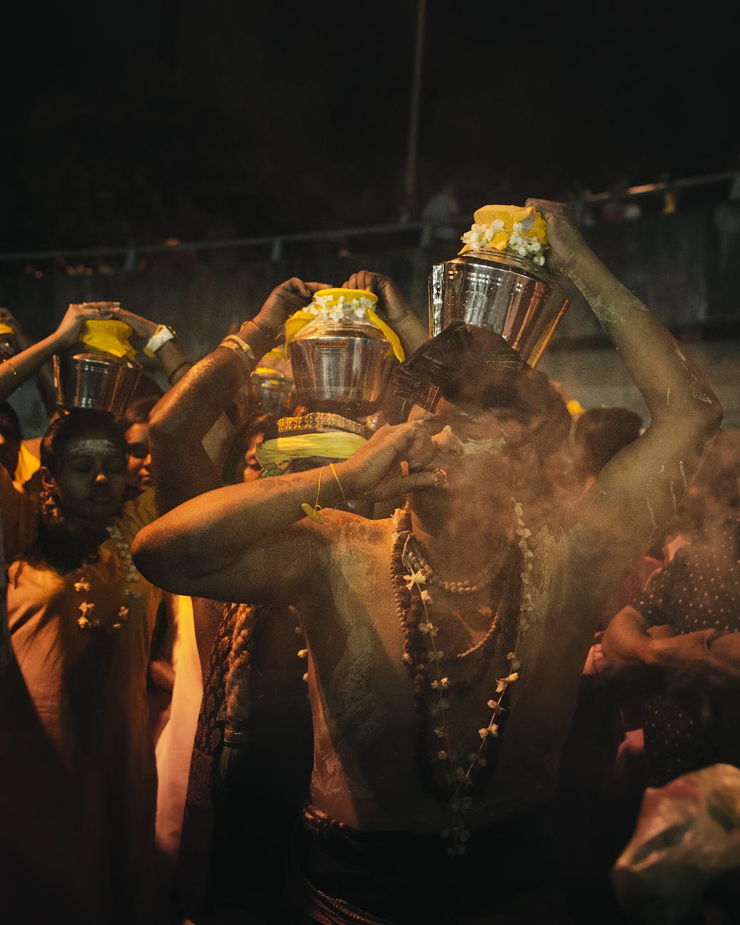 unrecognizable indian people on street during religious festival in evening