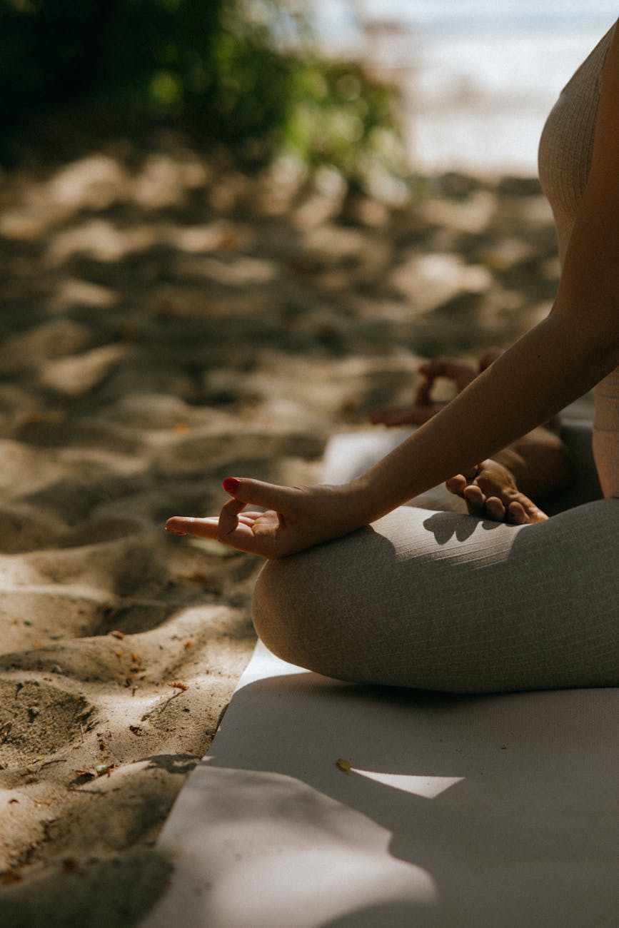 close up shot of a person sitting on a yoga mat while meditating
