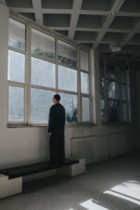 no thinking, man standing on bench and looking out of window