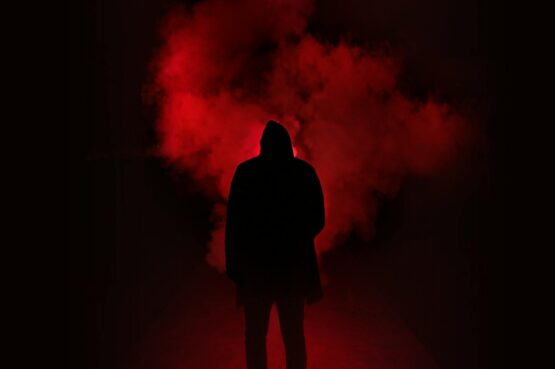 Never Outshine the Master, silhouette of man standing against black and red background