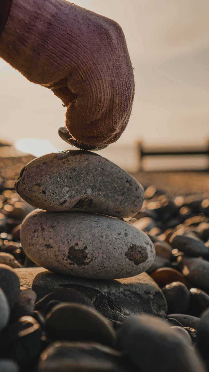 Vedic Secrets to Manifest Wealth, Success & Happiness Instantly! 7 stacking pebbles at sunrise on beach